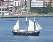 A three mast sailboat travels through Halifax harbor.
